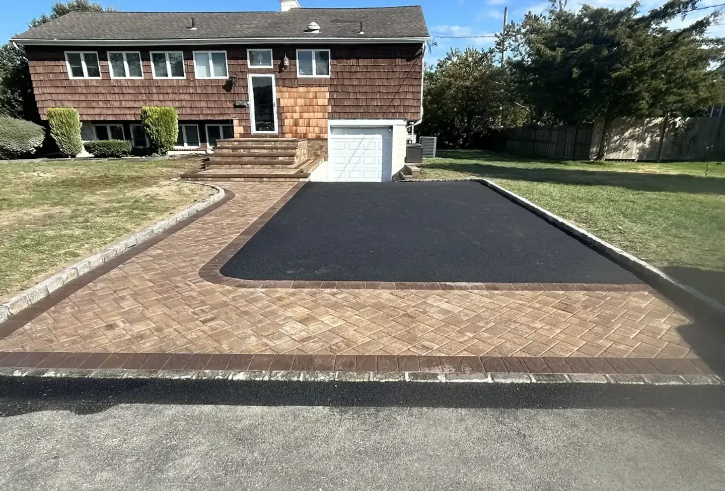 New asphalt driveway with a herringbone paver apron, border and walkway to the front steps of a Long Island home, by Promaster Maintenance Corp