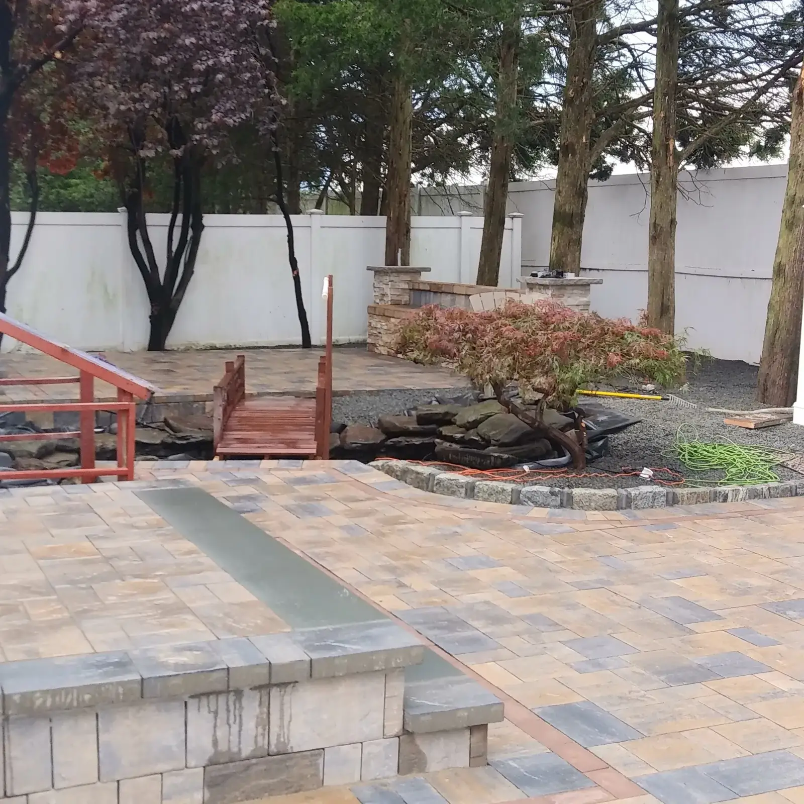 Paver patio with pond and seat wall by Promaster Maintenance Corp, Long Island, NY