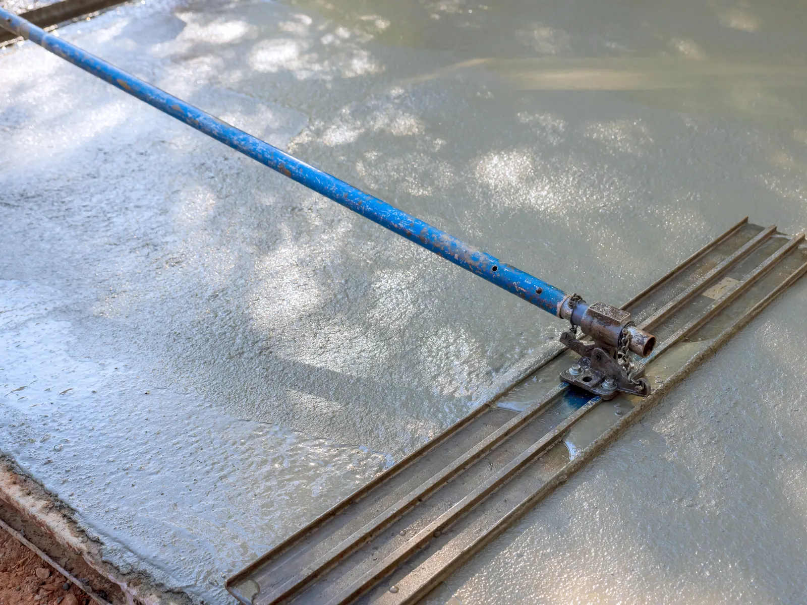 Bull float smoothing a fresh concrete slab