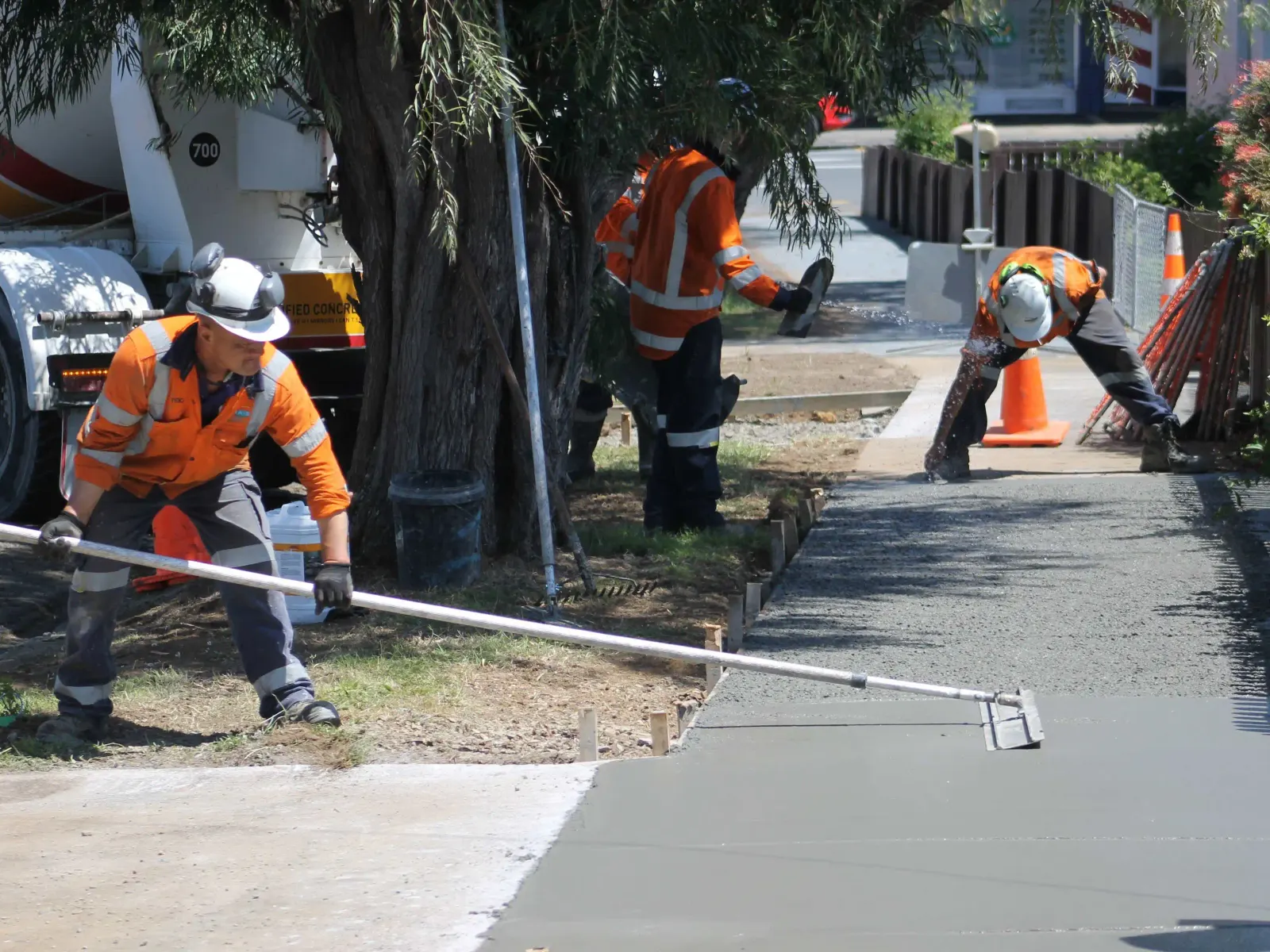 Crew finishing a new concrete sidewalk