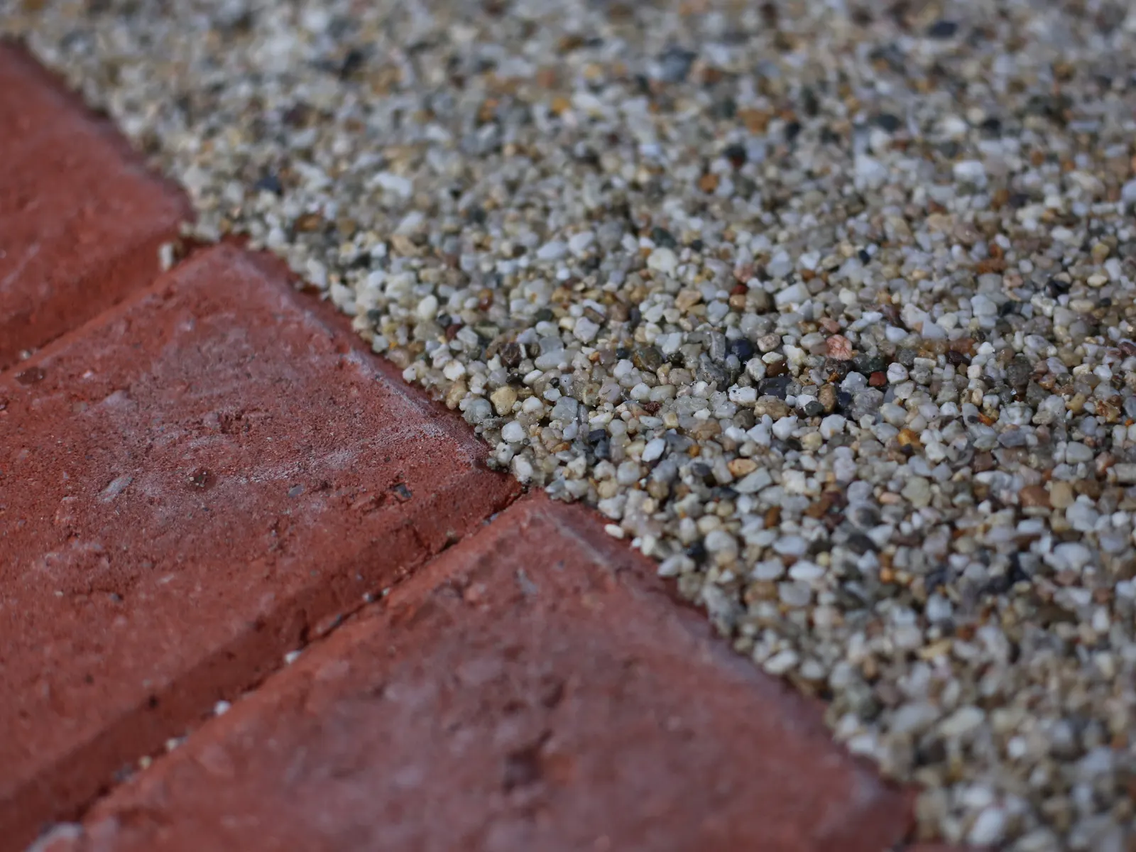 Resin bound surfacing meeting a brick edge